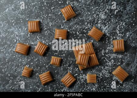 Gesalzene Karamellstücke auf schwarzem rauchigen Hintergrund Stockfoto