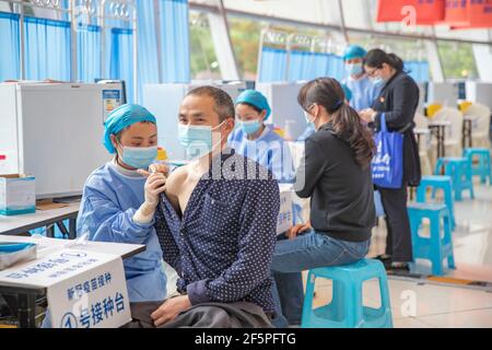 Chongqing, China. März 2021, 27th. Die Menschen erhalten COVID-19-Impfstoffe an einer temporären Impfstelle im Bezirk Nan'an in Chongqing, Südwestchina, 27. März 2021. In zwei Sportzentren im Bezirk Jiulongpo und im Bezirk Nan'an in Chongqing wurden zwei temporäre Impfstellen eingerichtet, die eine tägliche Impfkapazität von etwa 5.000 bzw. 10.000 haben. Quelle: Huang Wei/Xinhua/Alamy Live News Stockfoto