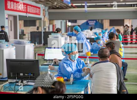 Chongqing, China. März 2021, 27th. Die Menschen erhalten COVID-19-Impfstoffe an einer temporären Impfstelle im Bezirk Jiulongpo in Chongqing, Südwestchina, 27. März 2021. In zwei Sportzentren im Bezirk Jiulongpo und im Bezirk Nan'an in Chongqing wurden zwei temporäre Impfstellen eingerichtet, die eine tägliche Impfkapazität von etwa 5.000 bzw. 10.000 haben. Quelle: Huang Wei/Xinhua/Alamy Live News Stockfoto