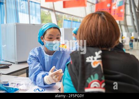 Chongqing, China. März 2021, 27th. Ein Bewohner erhält einen Schuss COVID-19-Impfstoff an einer temporären Impfstelle im Bezirk Nan'an in Chongqing, Südwestchina, 27. März 2021. In zwei Sportzentren im Bezirk Jiulongpo und im Bezirk Nan'an in Chongqing wurden zwei temporäre Impfstellen eingerichtet, die eine tägliche Impfkapazität von etwa 5.000 bzw. 10.000 haben. Quelle: Huang Wei/Xinhua/Alamy Live News Stockfoto