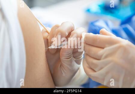 Chongqing, China. März 2021, 27th. Ein Bewohner erhält einen Schuss COVID-19-Impfstoff an einer temporären Impfstelle im Bezirk Nan'an in Chongqing, Südwestchina, 27. März 2021. In zwei Sportzentren im Bezirk Jiulongpo und im Bezirk Nan'an in Chongqing wurden zwei temporäre Impfstellen eingerichtet, die eine tägliche Impfkapazität von etwa 5.000 bzw. 10.000 haben. Quelle: Huang Wei/Xinhua/Alamy Live News Stockfoto