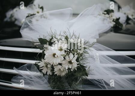Graustufen-Aufnahme eines Hochzeitswagens mit schönen Blumendekorationen Stockfoto