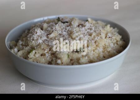 UPMA oder Uppuma ist ein gemeinsames südindisches und Sri Lanka tamilisches Frühstücksgericht, gekocht als dickes Haferflocken aus trockenem gebratenem Grieß oder grobem Reismehl Stockfoto