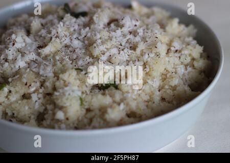 UPMA oder Uppuma ist ein gemeinsames südindisches und Sri Lanka tamilisches Frühstücksgericht, gekocht als dickes Haferflocken aus trockenem gebratenem Grieß oder grobem Reismehl Stockfoto