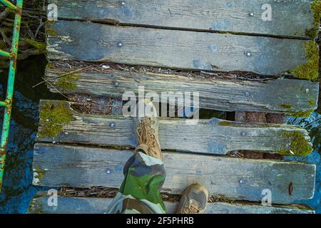 Spaziergang auf einer Holzbrücke über einen Fluss Stockfoto