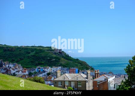 Staycation Idee. Erhöhter Blick auf den Hastings Country Park, den East Hill Lift, die Dächer der Häuser und den Ärmelkanal, vom West Hill aus gesehen. East Sussex. Stockfoto