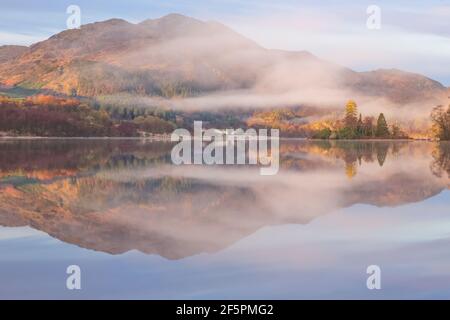 Eine ruhige, ruhige Berglandschaft mit Morgennebel am Loch Achray am Loch Lomond & dem Trossachs National Park in den schottischen Highlands, Stockfoto