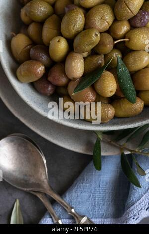 Marinierte Oliven mit Kräutern und Gewürzen, gesunde natürliche Lebensmittelzutaten Stockfoto