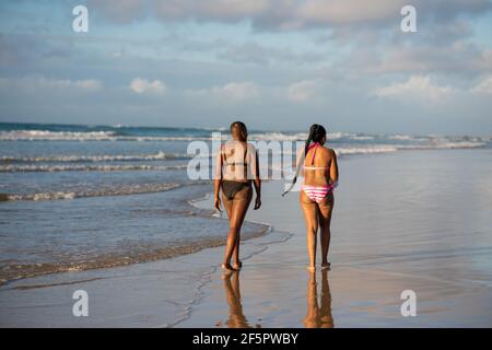 Zwei Damen, die am Strand spazieren Stockfoto