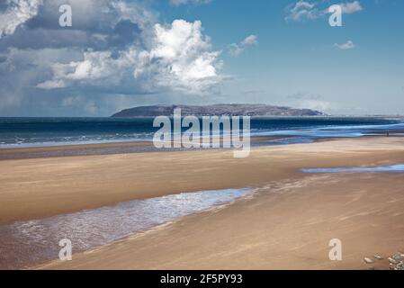 Penmaenmawr Beach, in der Nähe der Stadt Penmaenmawr in Nord-Wales, ist ein langer Sandstrand neben der Menai Straits. Stockfoto