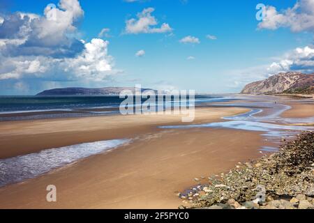 Penmaenmawr Beach, in der Nähe der Stadt Penmaenmawr in Nord-Wales, ist ein langer Sandstrand neben der Menai Straits. Stockfoto