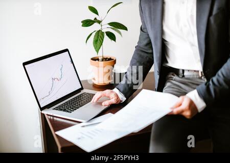 Finanzmanager analysiert Preisdaten Trenddiagramm auf Laptop in Büro Stockfoto