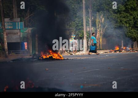 Yangon, Myanmar. März 2021, 27th. Eine Frau, die während der Demonstration an den brennenden Reifen vorbeiläuft. Myanmar Militär greift Demonstranten mit Gummigeschossen, lebender Munition, Tränengas und Schallbomben als Reaktion an. Die Zahl der Todesopfer beträgt heute 144 und die höchste Zahl der Todesopfer seit dem Militärputsch im Februar 1. (Foto von Theint Mon Soe/SOPA Images/Sipa USA) Quelle: SIPA USA/Alamy Live News Stockfoto