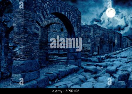 Pompeji bei Nacht, Italien. Mystische apokalyptische Ansicht der zerstörten Häuser der alten Stadt im Vollmond. Gruselige dunkle Szene für Halloween-Thema. Konzept von h Stockfoto