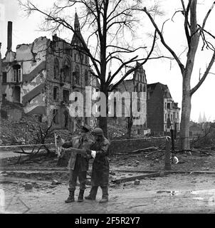 Köln, Deutschland 1945 Königlicher Luftwaffenoffizier und Dispatch-Fahrer inspizieren Bombenschäden gegen Ende des Zweiten Weltkriegs nach schweren Bombenangriffen auf die Stadt. WW2 zweiter Weltkrieg Stockfoto