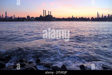 Blick über den East River von Williamsburg in der Dämmerung, Midtown Skyline vor dem Hintergrund des Sonnenuntergangs Himmel, Silhouette des Con Edison Kraftwerks Stockfoto