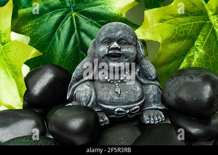 Buddha und Stapel von schwarzen Basaltsteinen Stockfoto