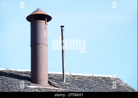 Schornstein am Schieferdach des Gebäudes Stockfoto