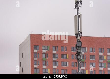 Ausrüstung des Mobilfunkanbieters. 3G und 4G Sender hängen hoch an einer Stange. Zellenturm in der Stadt. Stockfoto