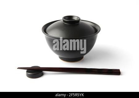 Donburi Reis Schüssel schwarz mit Essstäbchen isoliert auf weißem Hintergrund Stockfoto