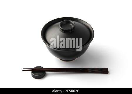 Donburi Reis Schüssel schwarz mit Essstäbchen isoliert auf weißem Hintergrund Stockfoto