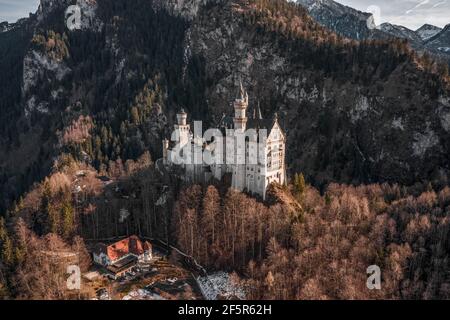 Luftdrohnenaufnahme des malerischen Schlosses Neuschwanstein auf einem verschneiten Hügel Im Winter Sonnenlicht in Deutschland Stockfoto