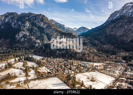 Luftdrohnenaufnahme des malerischen Schlosses Neuschwanstein auf einem verschneiten Hügel Im Winter Sonnenlicht in Deutschland Stockfoto