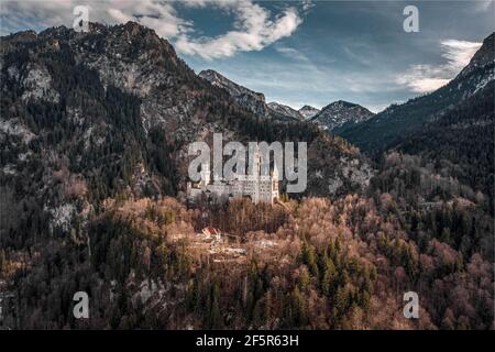 Luftdrohnenaufnahme des malerischen Schlosses Neuschwanstein auf einem verschneiten Hügel Im Winter Sonnenlicht in Deutschland Stockfoto