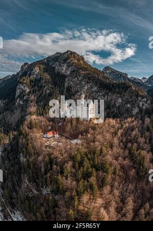 Luftdrohnenaufnahme des malerischen Schlosses Neuschwanstein auf einem verschneiten Hügel Im Winter Sonnenlicht in Deutschland Stockfoto