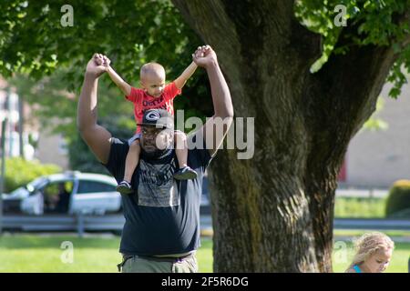 African American Dad - Vater trägt junge Sohn oder Kleinkind Bei Protest Stockfoto