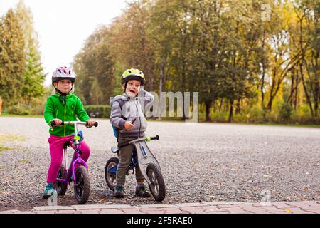 Süße Kinder auf Laufrädern im Freien im Park Stockfoto