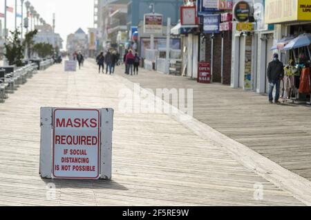 Während der COVID-19-Pandemie in der Nebensaison auf der Promenade von Ocean City, Maryland, USA, mussten Masken ein Warnschild tragen Stockfoto