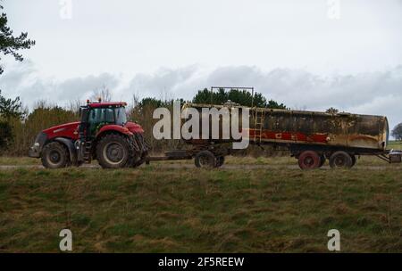 Case Puma 340 roter Traktor, der einen 30,000 Liter Wasseranhänger schleppt Stockfoto