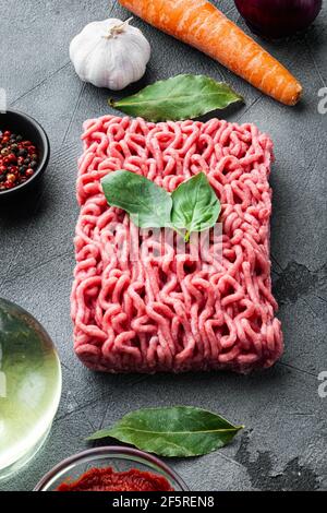 Traditionelle italienische Tomatensauce Bolognese mit Zutaten, Hackfleischtomate und Kräuter Set, auf grauem Stein Hintergrund Stockfoto