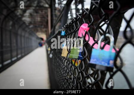 Vorhängeschlösser, die am Stahlzaun befestigt sind, der die Eisenbahnbrücke im Harpers Ferry National Park in West Virginia, USA, sät Stockfoto