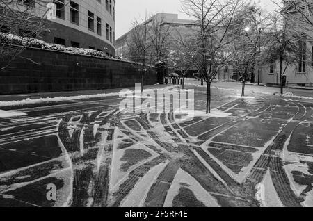 Autoreifspuren, die während eines Wintereissturms in Richmond, Virginia, USA im Eis und Schnee gemacht wurden. Stockfoto