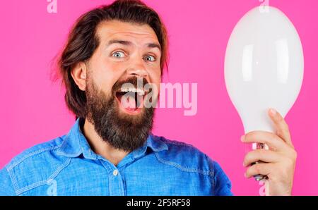 Glücklicher Mann mit Lampe. Lächelnder Bartmann mit Glühbirne. Gute Idee. Die Geburt von Ideen. Stockfoto