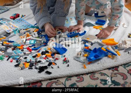 Geschwister spielen mit Spielzeugsteinen auf dem Boden Stockfoto
