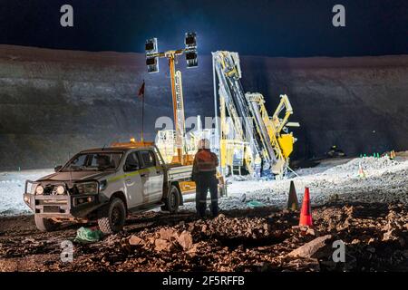 Bohranlage, die nachts in einer Tagebaumine betrieben wird Flutlichter Stockfoto