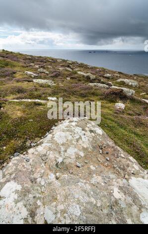 Ein stürmischer, regnerischer Tag mit Blick in den Atlantik zum Leuchtturm von Longships von Land's End in Cornwall, England. Stockfoto