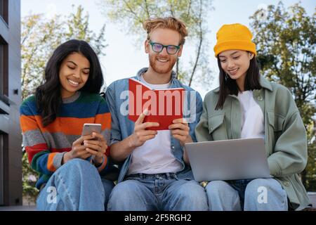 Gruppe glücklicher multirassischer Studenten, die zusammen studieren, Sprache lernen, sich auf die Prüfung vorbereiten, Bildungskonzept Stockfoto