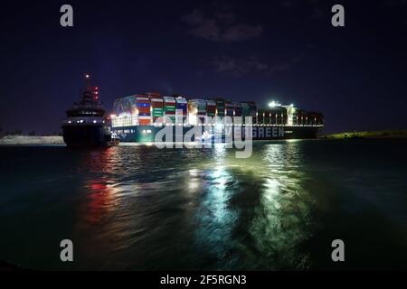 Suezkanal, Ägypten. März 2021, 27th. Rettungsschiffe arbeiten am Standort des festsitzenden Containerschiffes, das am 27. März 2021 auf dem Suezkanal in Ägypten abgegeben wurde. Mindestens 321 Schiffe sind derzeit rund um den Suezkanal in Erwartung Bergung des riesigen Containerschiffes je gegeben, dass stecken geblieben und blockiert die lebenswichtige Wasserstraße seit Dienstag, Osama Rabie, Vorsitzender der Suezkanal Authority (SCA), sagte Samstag. Er wies darauf hin, dass 14 Schlepper arbeiten, um jemals aus allen Richtungen gegeben zu retten. Quelle: Ahmed Gomaa/Xinhua/Alamy Live News Stockfoto