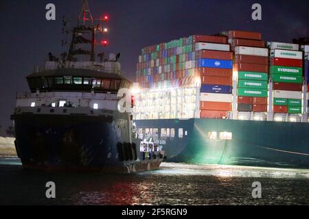 Suezkanal, Ägypten. März 2021, 27th. Ein Rettungsschiff arbeitet am Standort des festsitzenden Containerschiffes, das am 27. März 2021 auf dem Suezkanal in Ägypten abgegeben wurde. Mindestens 321 Schiffe sind derzeit rund um den Suezkanal in Erwartung Bergung des riesigen Containerschiffes je gegeben, dass stecken geblieben und blockiert die lebenswichtige Wasserstraße seit Dienstag, Osama Rabie, Vorsitzender der Suezkanal Authority (SCA), sagte Samstag. Er wies darauf hin, dass 14 Schlepper arbeiten, um jemals aus allen Richtungen gegeben zu retten. Quelle: Ahmed Gomaa/Xinhua/Alamy Live News Stockfoto