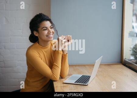 Porträt von glücklichen Texter mit Laptop-Computer, Planung Projekt. Lächelnde afroamerikanische Frau, die von zu Hause aus arbeitet. Erfolgreiches Geschäftskonzept Stockfoto