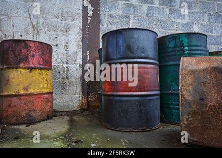 Alte Chemiefässer. Blaue, grüne rote und rostige Öltrommel. Stahlöltank. Lager für giftige Abfälle. Gefährliche Chemikalienfass Stockfoto