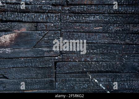 Verbrannter Holzbrett Hintergrund. Details der Oberfläche von verkohltem Holz. Stockfoto