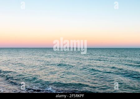 Pastellfarben am Horizont, wenn die Sonne untergeht Das Meer Stockfoto