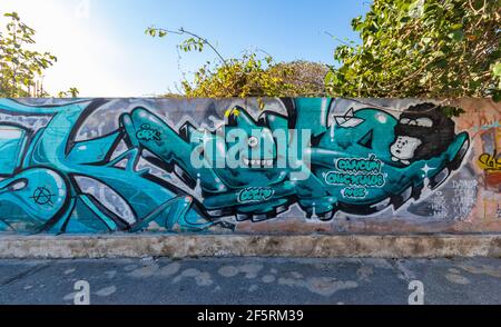 Segment einer langen Wand der Street Art in Mexiko, mit einem Cartoon-Mädchen Gesicht und eine stilisierte Kreatur in der Mitte der Buchstaben Stockfoto