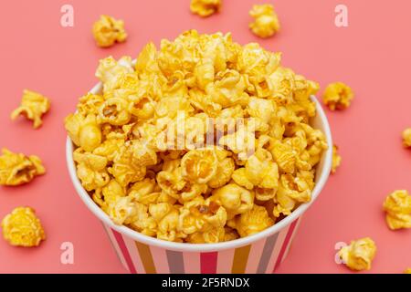 Karamell von Pop-Icons in bunten Cups auf rosa Hintergrund Stockfoto