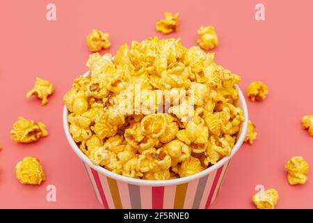 Karamell von Pop-Icons in bunten Cups auf rosa Hintergrund Stockfoto